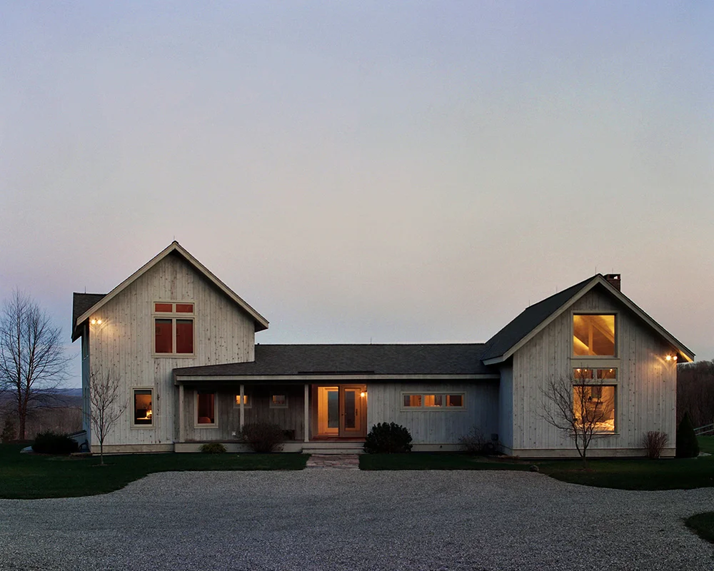 A large white house with two windows and a driveway.