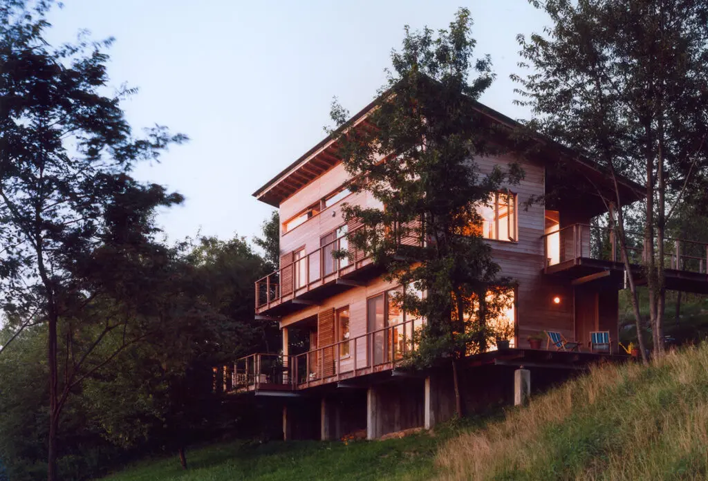 A house with a deck and trees in the background