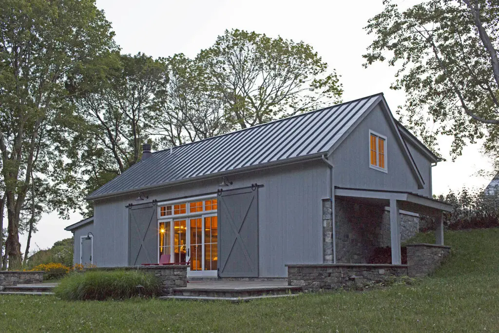 A large gray barn with a metal roof.