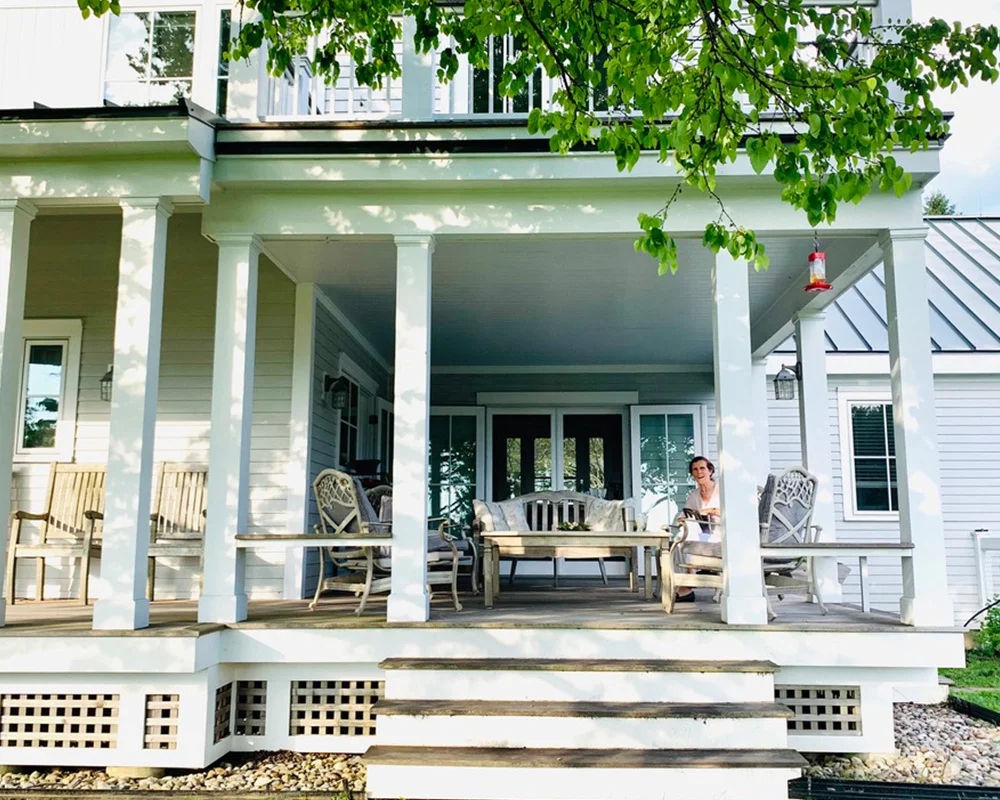 A person sitting on the porch of a house.