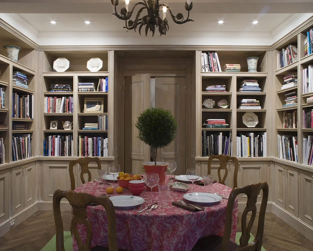 A dining room table with four chairs and a potted plant.